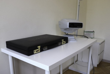 Стол в кабинете врача с медицинскими прибором и кейсом